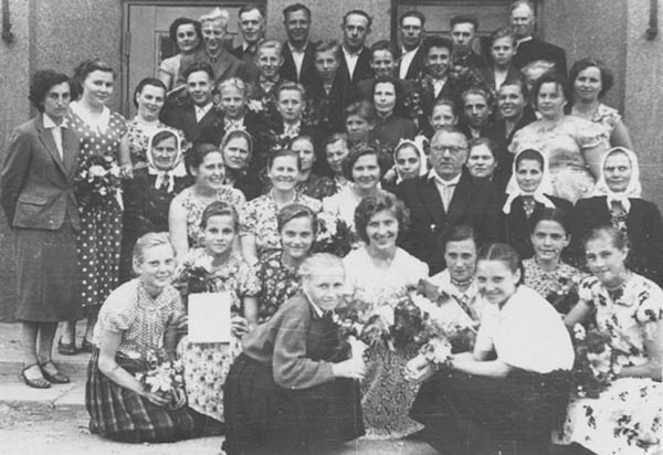Sustabdyta aštuonmetės mokyklos gyvenimo akimirka, septintojo dešimtmečio pradžia. Viduryje sėdi direktorius Juozas Augonis.