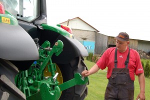 Su naujuoju „John Deere“ dirbsiantis Deimanto Kairiūkščio sesers vyras Rimantas Kučinskas apžiūri, kur netrukus turės prikabinti purkštuvą.