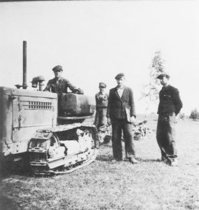Mykolas Kazlauskas Sundakuose prie naujos modifikacijos traktoriaus, dirbant MTS (Mykolas - antras iš dešinės)